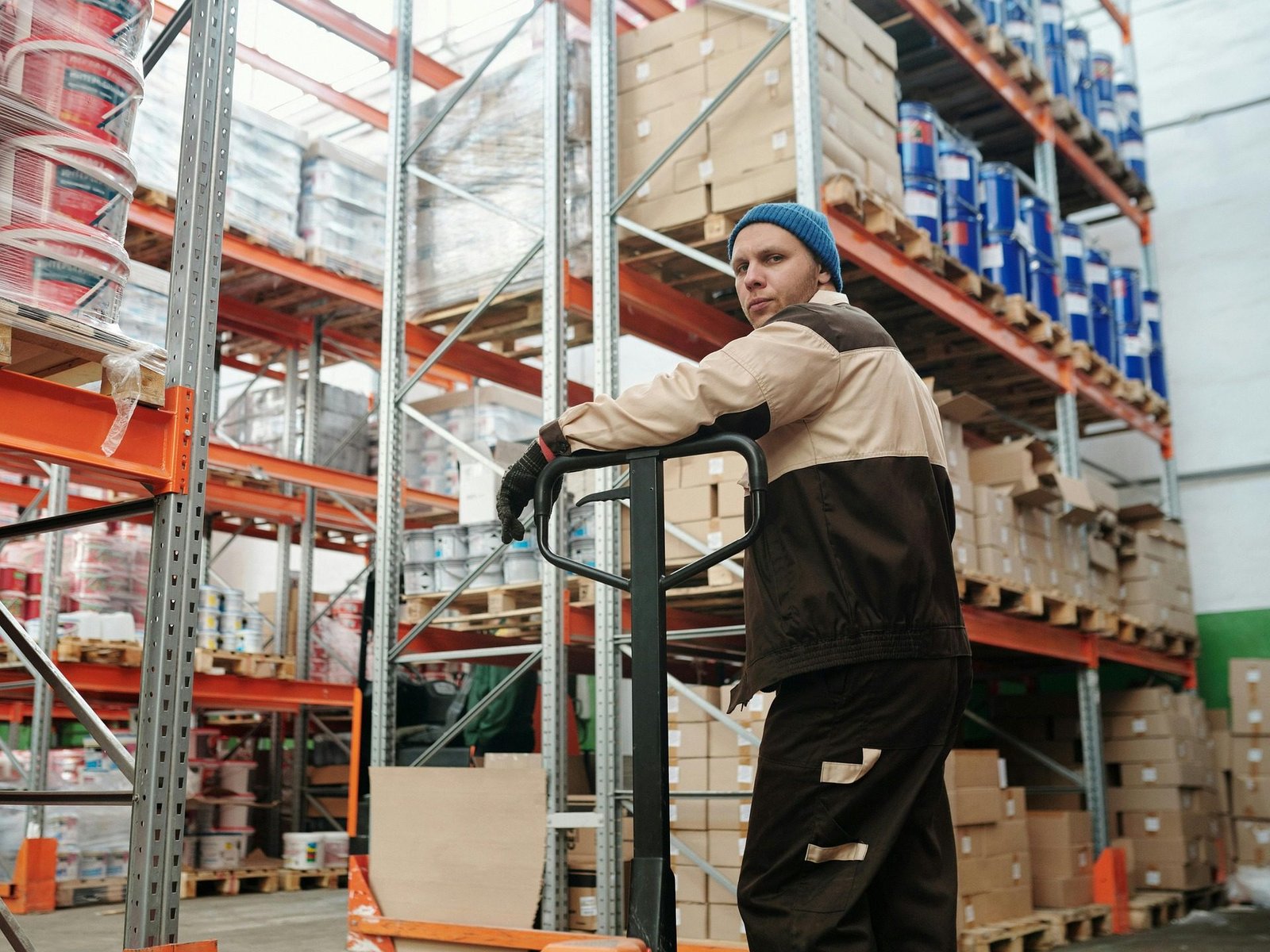 Cariste manœuvrant un transpalette dans un entrepôt logistique